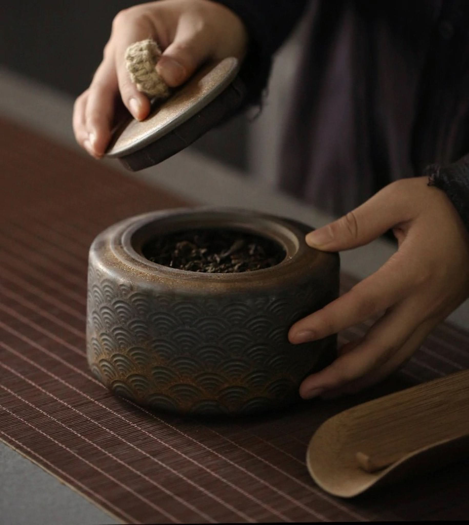 Vintage kitchen canister with Japanese wave pattern, holding tea leaves.